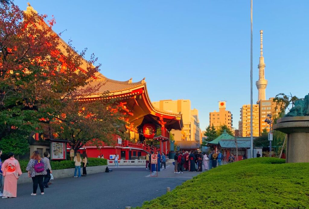 Senso-ji Temple in Asakusa, Tokyo, with tourists walking along Nakamise Street and Shin-Nakamise