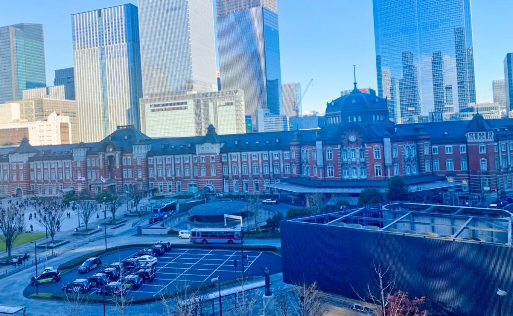 Tokyo Station surrounded by modern skyscrapers, combining historical charm and a hub of convenience for travelers.